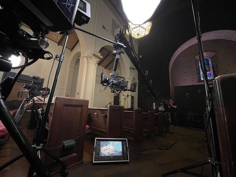 Jib — arm reaching out over the seating in a church interior.