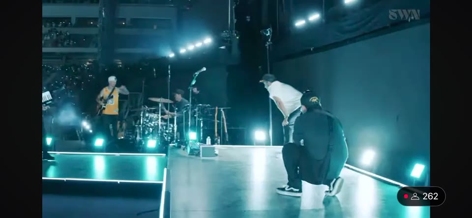 Summer Worship Nights Tour (2025) — Steadicam. Along the stage edge under the tour's lighting, the SWN mark overhead and the live stream's viewer counter in the corner of the frame.